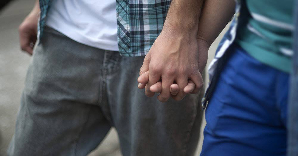 Close up of a gay couple holding hands