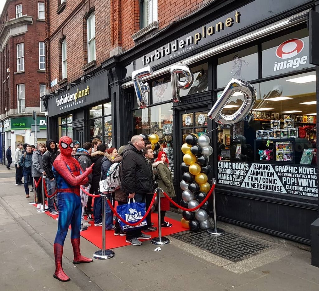 The queue outside Forbidden Planet Dublin on the launch party. A man dressed as Spider Man is pointing at the shop