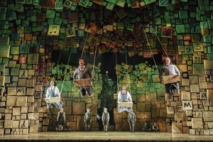 The children from Matilda the musical swinging on stage