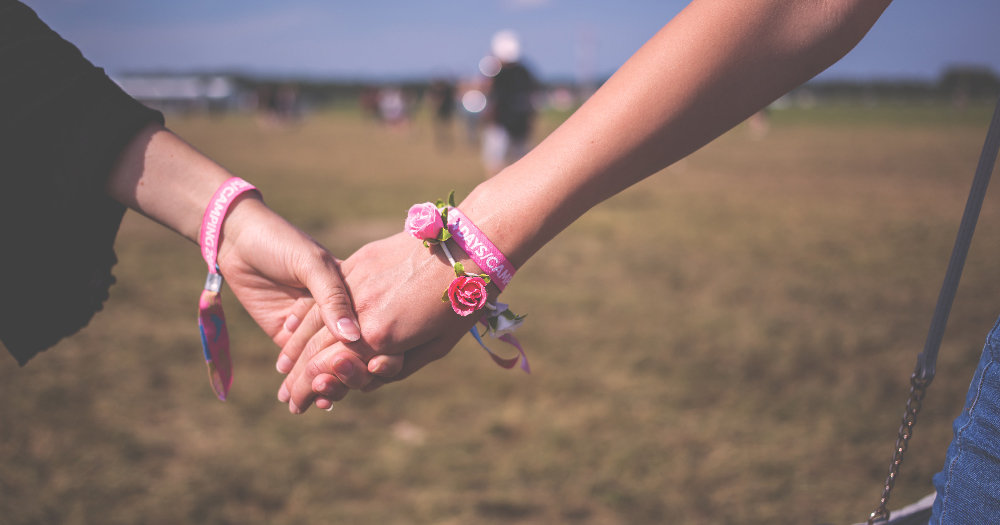 body&soul 2 girls wearing festival wristbands hold hands
