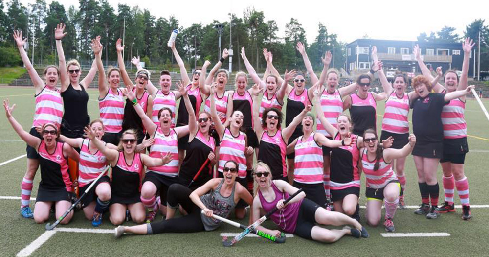 Pink Ladies hockey team posing in group shot on the pitch