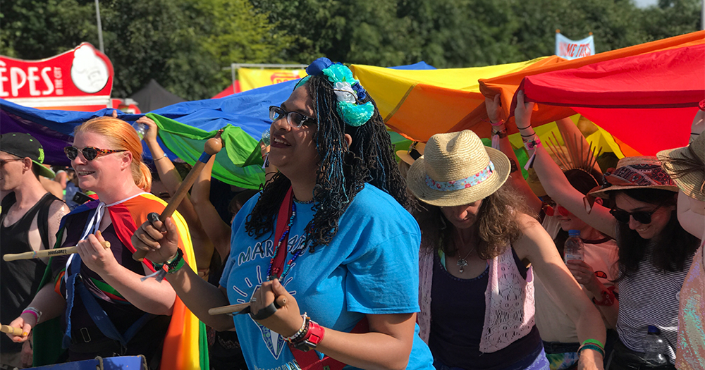A group of young woman at Body&Soul playing instruments and carrying a rainbow flag