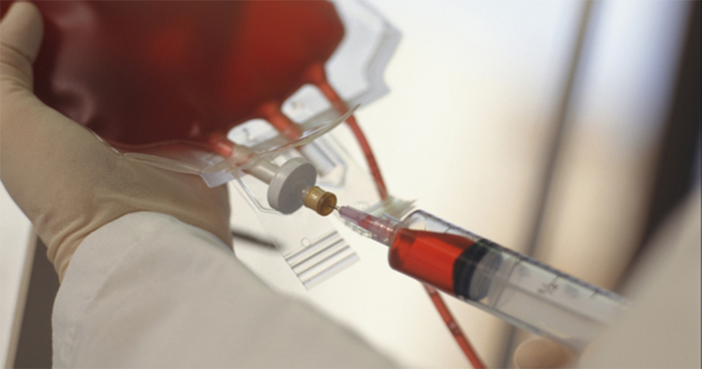 A syringe injecting blood into a plastic bag