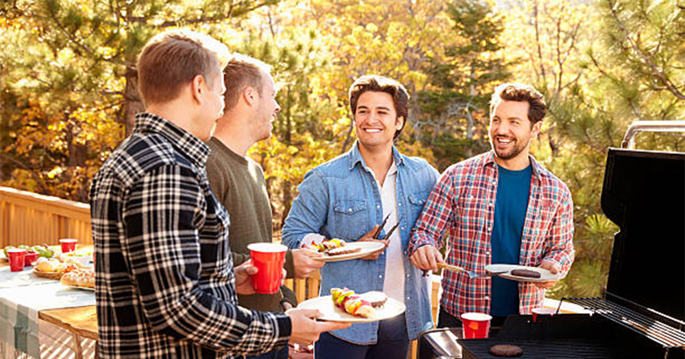 A group of men gathered around a barbecue