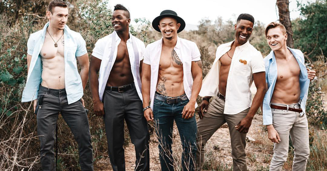 The Echo V lineup of five young men , two black, two white, one asian, all wearing open white shirts standing outdoors in a forested area