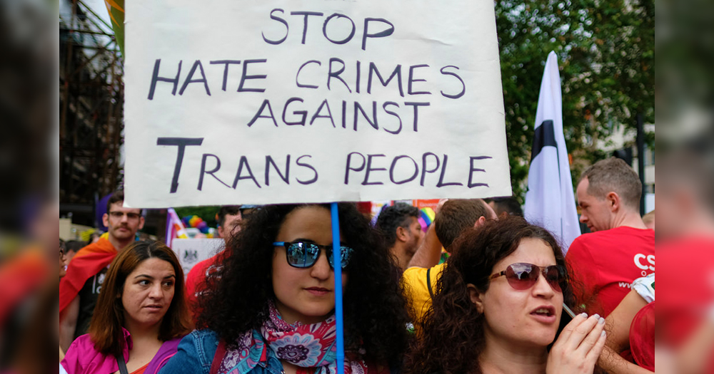 in Ireland a women holds a sign whihc says "stop hate crime against trans women"