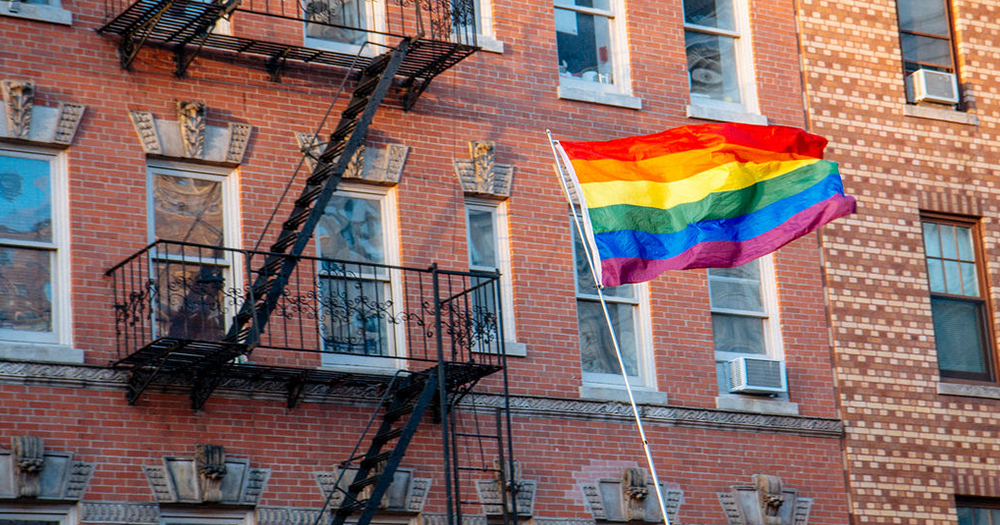 LGBT+ rainbow flag flied in front of an apartment block direct provision