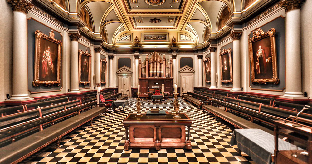 The Dublin Freemasons stately grand room with chequered carpet, wooden benches and oil paintings adorning the walls