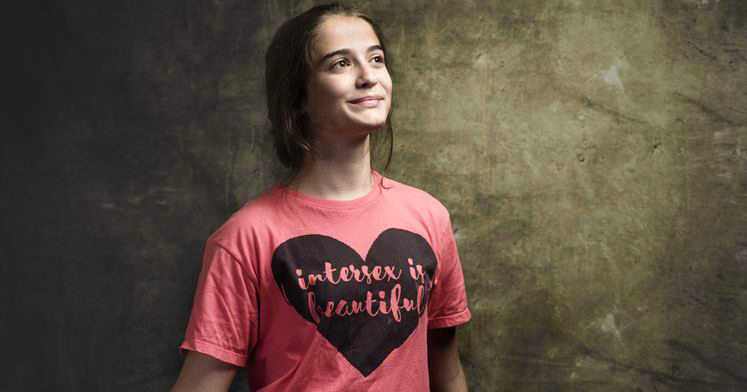 Intersex person wearing a t-shirt that reads "intersex is beautiful"