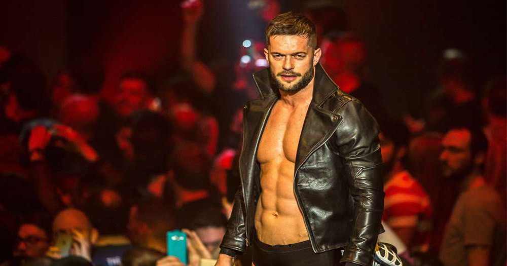 Wrestler Finn Bálor wearing a leather jacket poses at the side of the ring