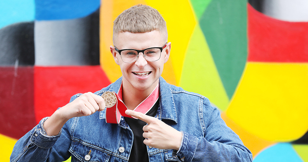 Paul Ryder poses for a photo with his Domino's pizza medal