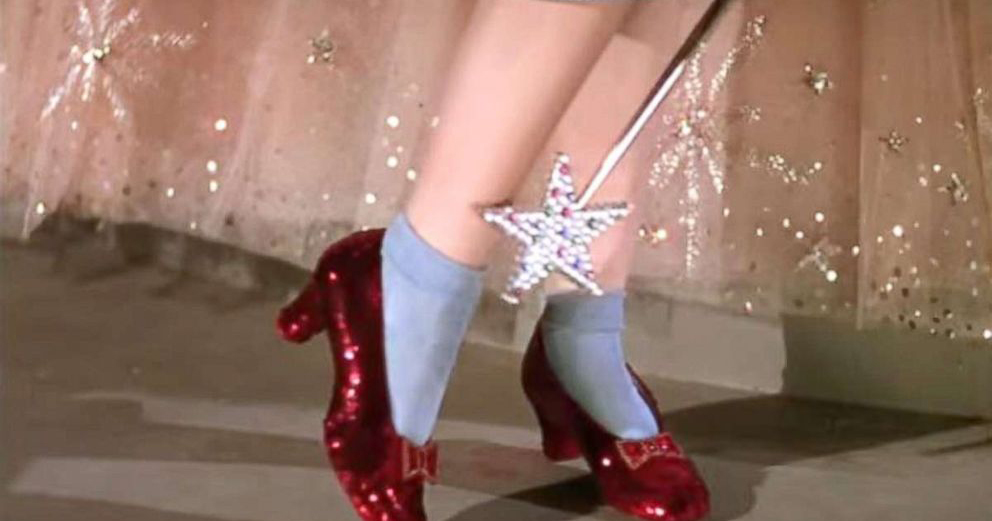 Image of the ruby slippers from a still of The Wizard of Oz. Glinda's wand is pointing at them.
