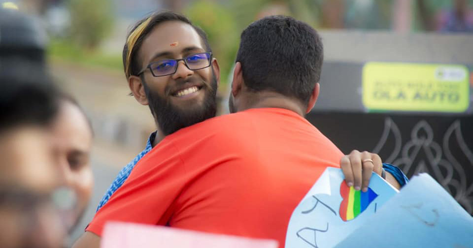 Image of two men hugging in India.