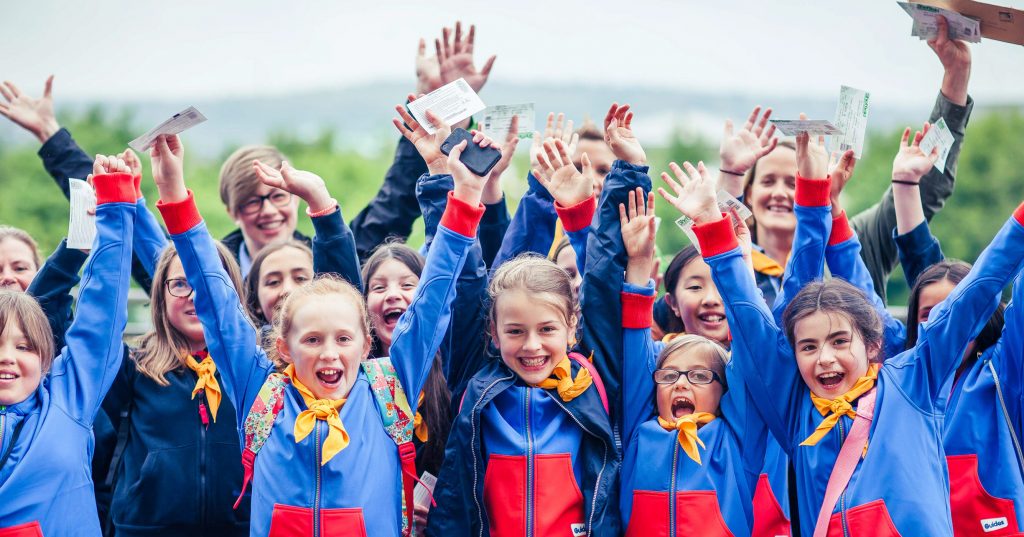 A group of young scouts cheering at a girlguiding event