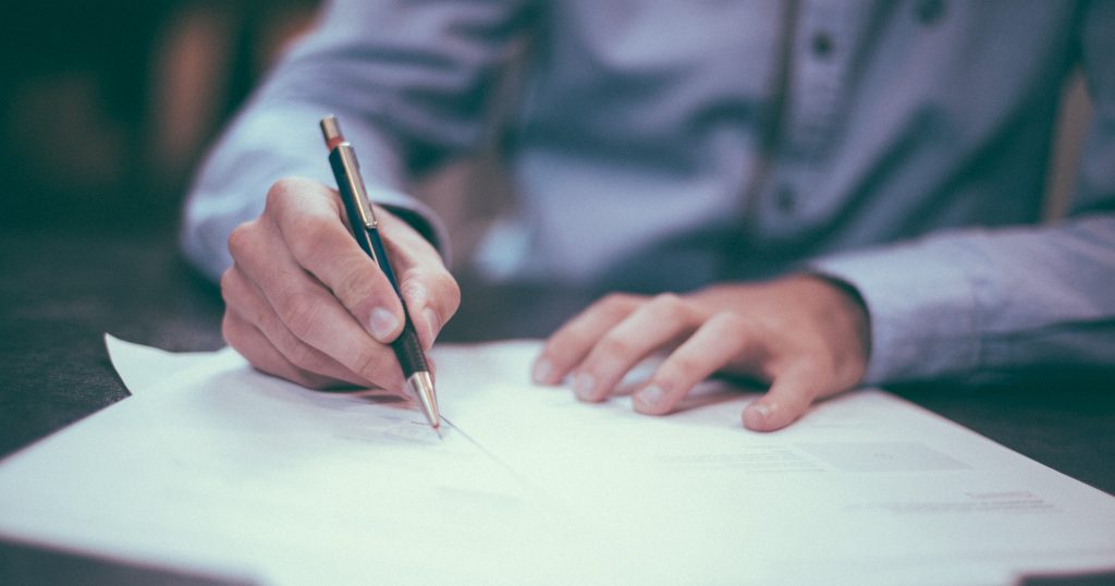 Image of a person signing a document