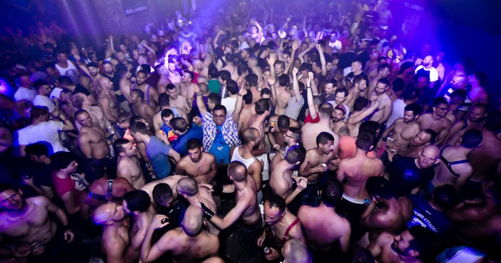 A crowd of topless men dancing inside the London club XXL