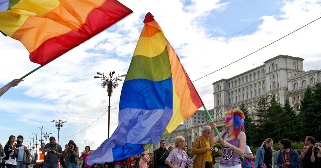 Girl waves rainbow flag at Bucharest Pride in Romania