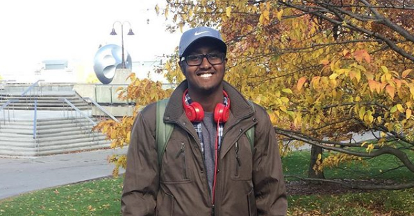 Image of Mahad Olad standing outside on a college campus.