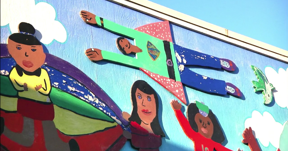 Image of a school mural showing children as superheroes.