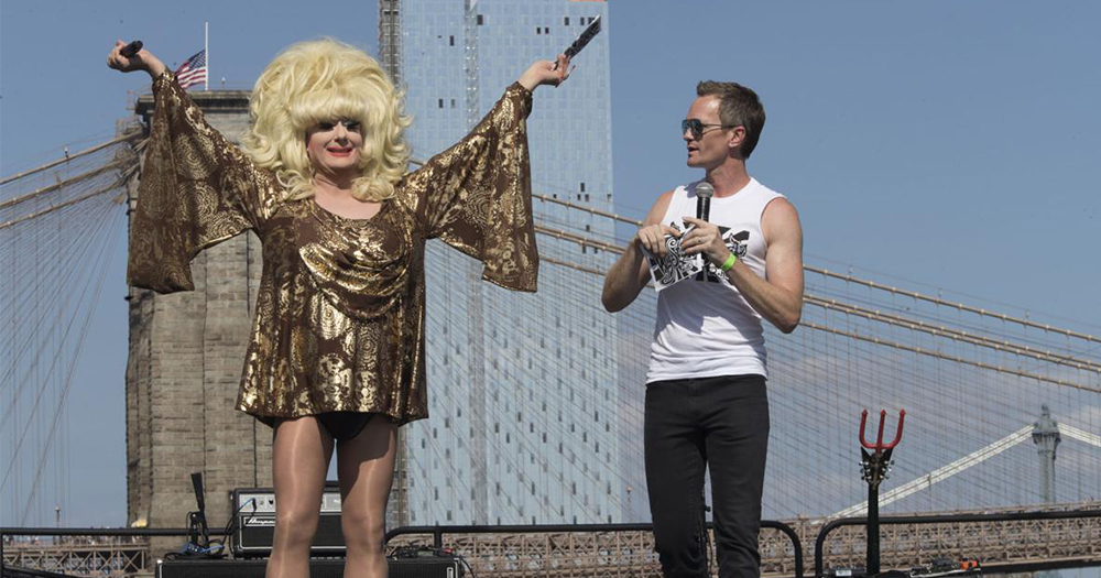 Drag queen Lady Bunny and actor Neil Patrick Harris on the Wigstock stage with the New York skyline in the background.