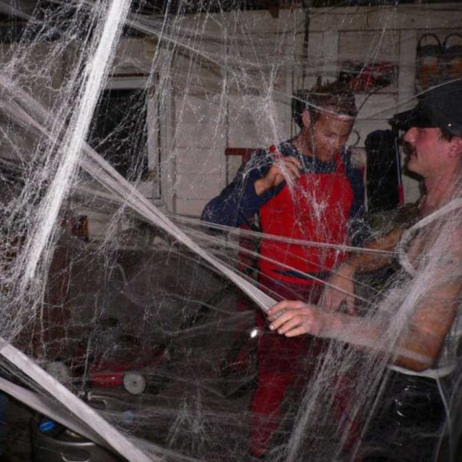 People tangled in cobwebs during a Halloween party