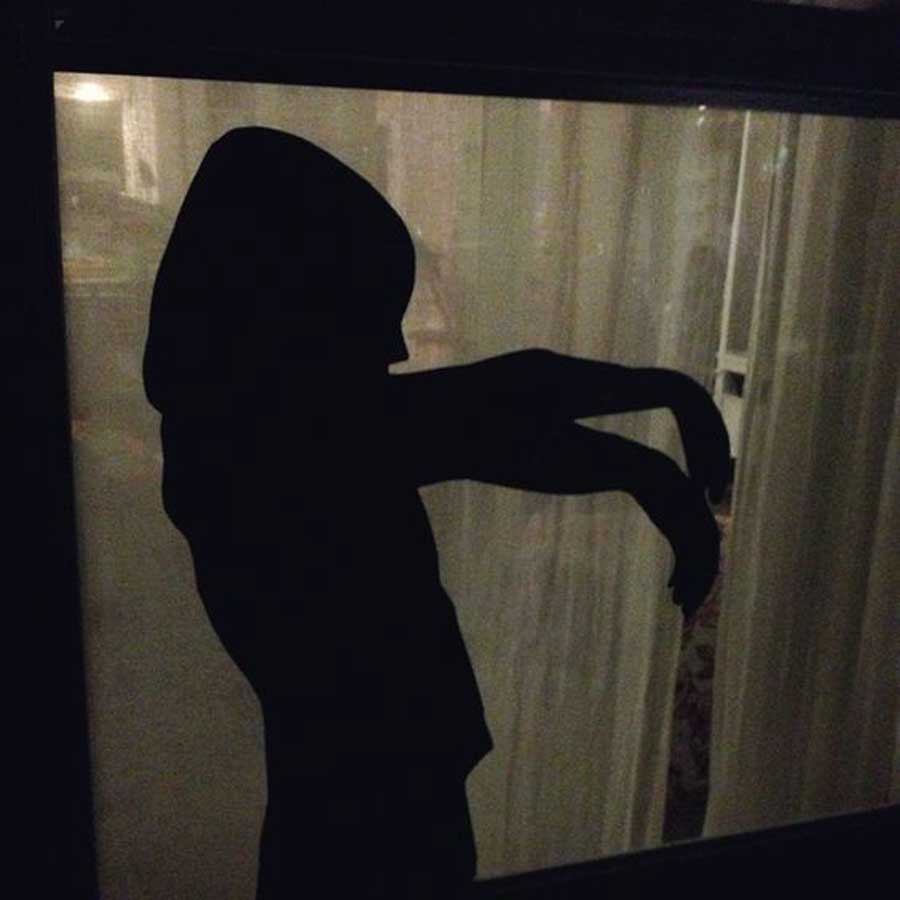 A creepy silhouette glued to the window used as decoration for a Halloween party