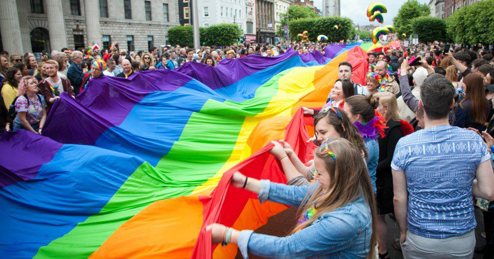 To represent National Coming Out Day, an image of hundreds of people holding a giant pride flag on O'Connell Street