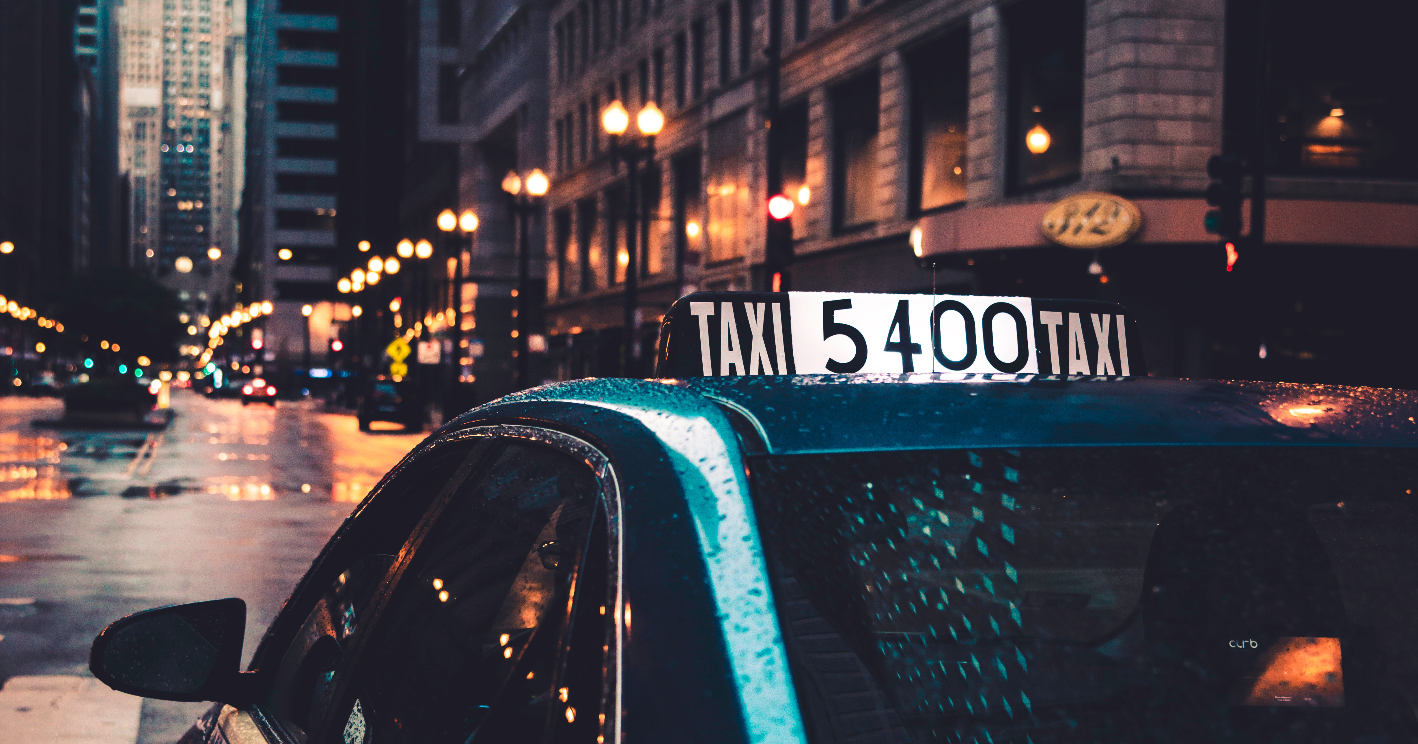 Image of a taxi in the rain. A woman's Twitter thread went viral after she shared her experience using Uber and Lyft.