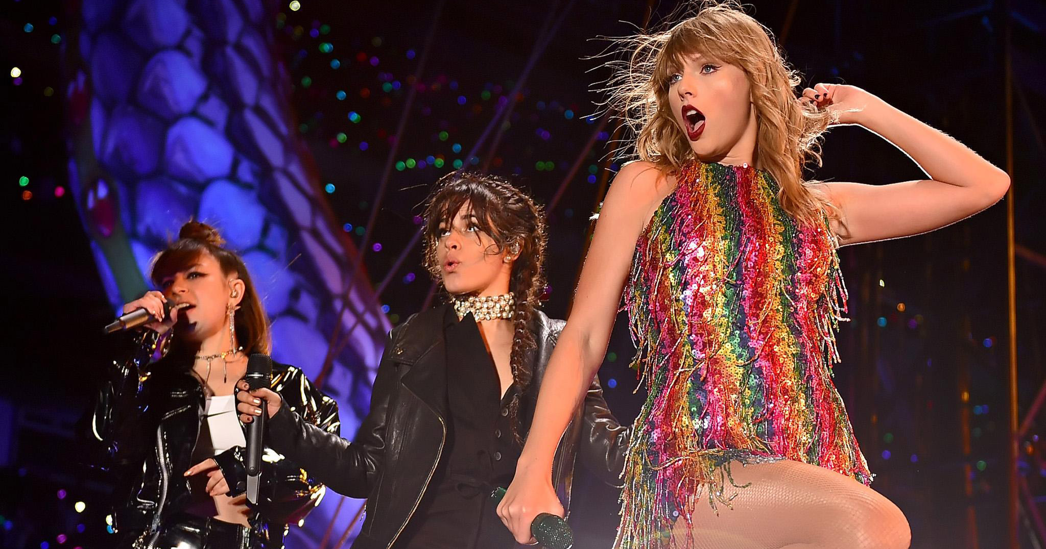 Taylor swift on stage wearing a rainbow dress on her 'Reputation' world tour, joined by Camila Cabello and Charli XCX