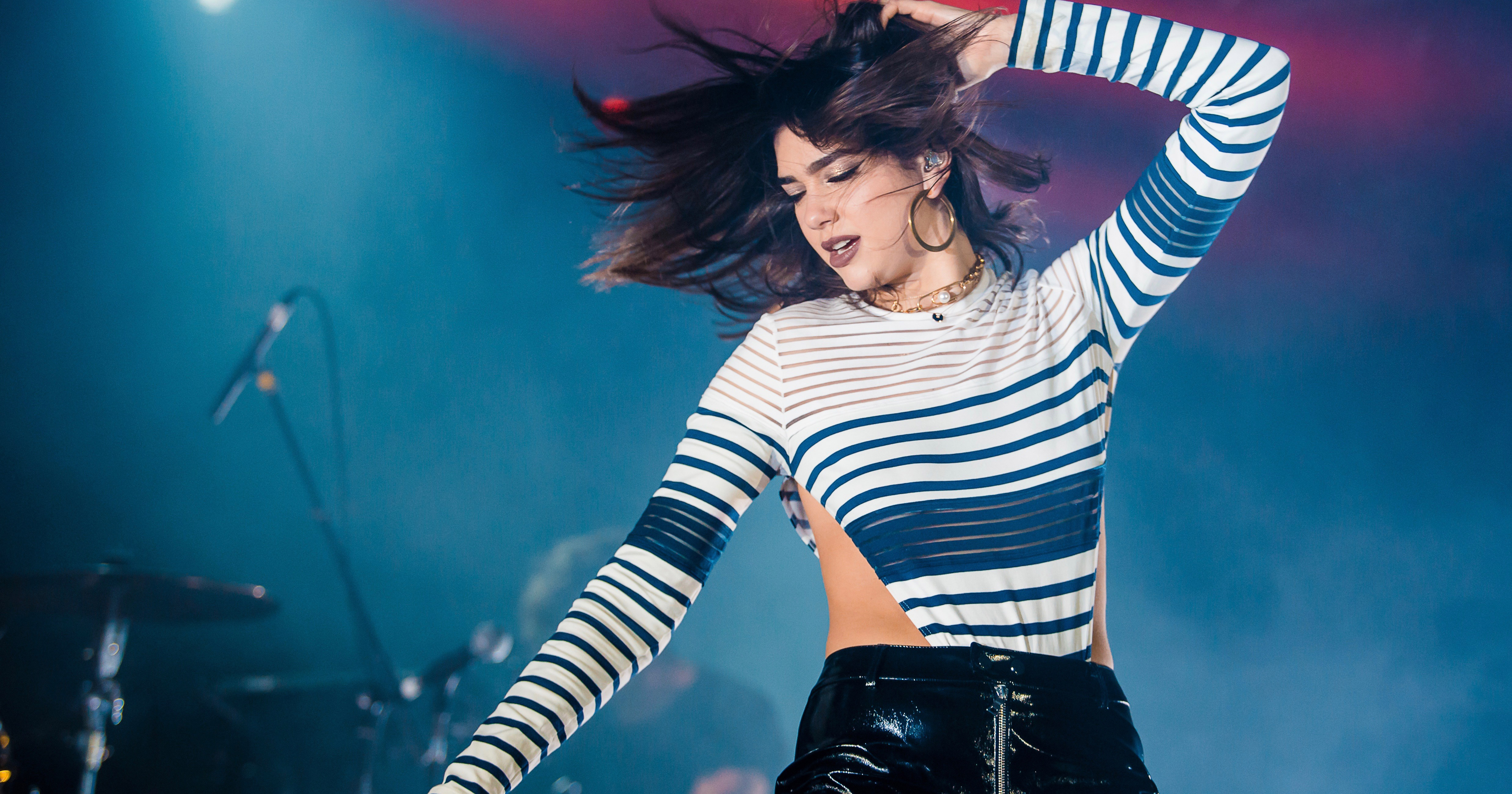 Dua Lipa dancing at a concert on stage