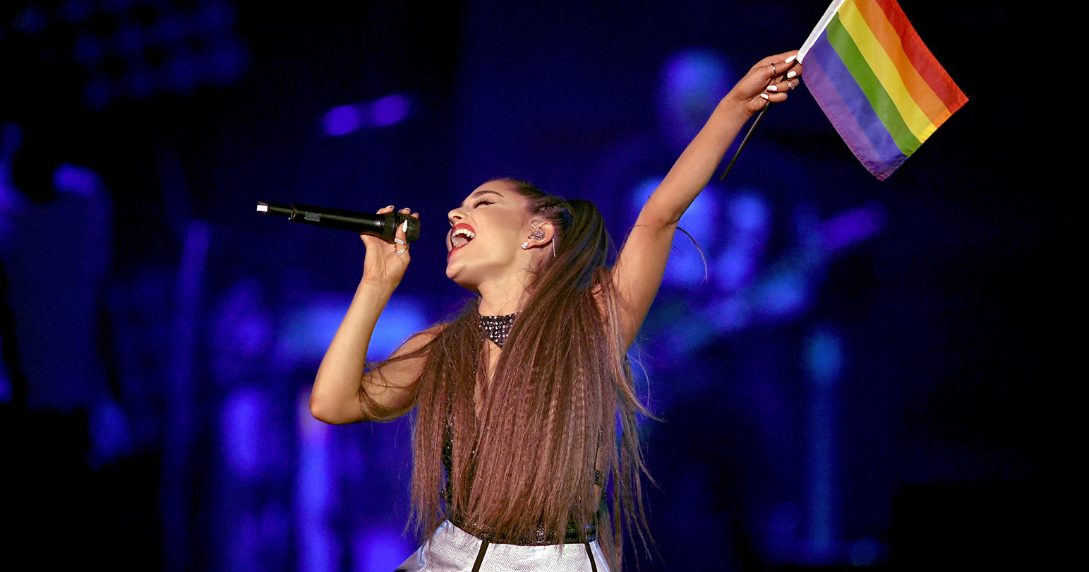 celebrity-allies-support-lgbt-community-2018 holding a pride flag as she sings on stage