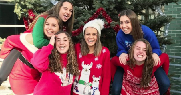 Emily Scheck and her friends in front of a Christmas tree.