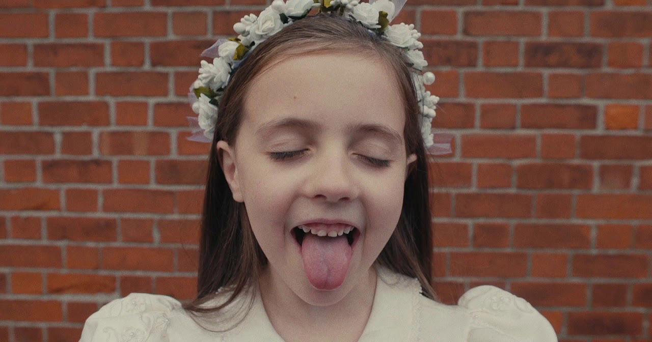 A still from Gay Girls, Pillow Queens new music video, showing a girl sticking out her tongue