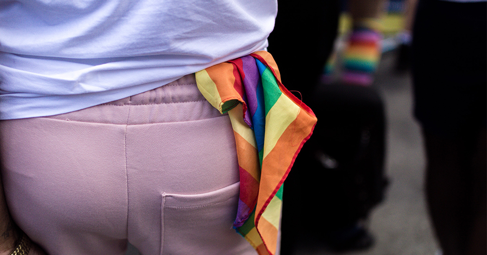 A rainbow coloured hankie representing gay lesbian bisexual and trans communities stuffed into the waistband of sweat pants