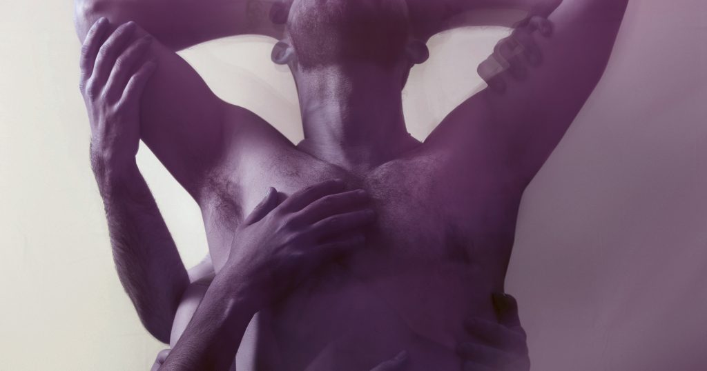 Man standing while hands are grabbing him at an after party