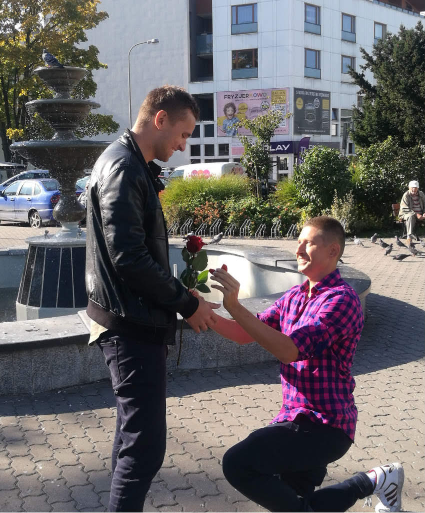 David proposes to Jakub in front of a fountain in a Polish town.