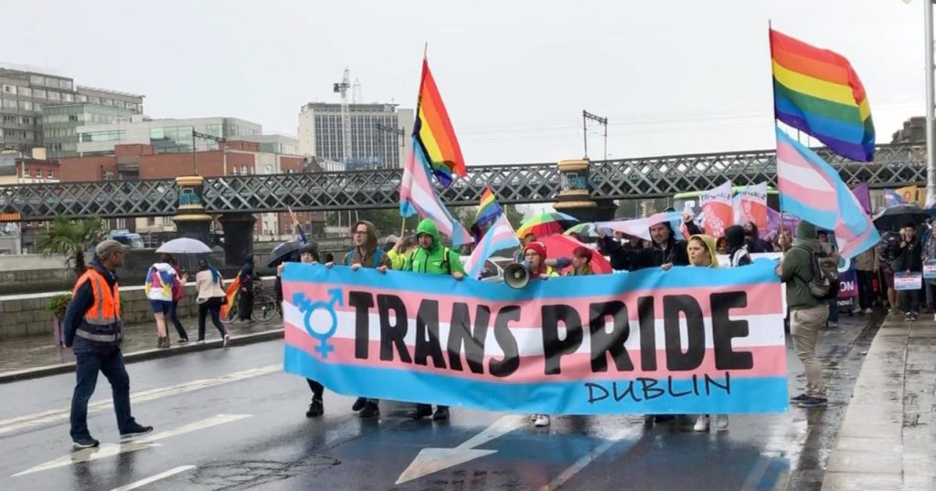 Members of the trans community marching through Dublin holding Trans Pride banners