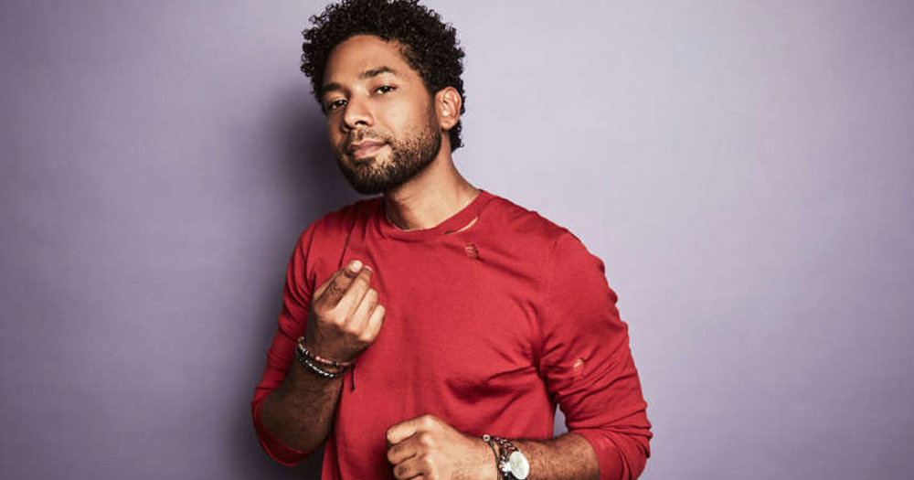 Jussie Smollett poses against a purple backdrop