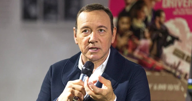 Kevin Spacey holding a microphone. 