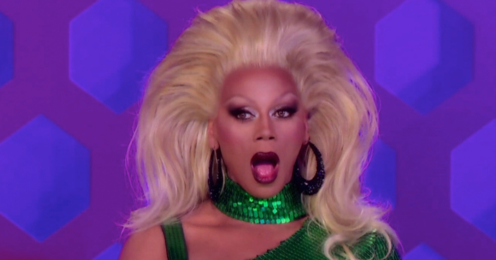 A picture of RuPaul in a blonde wig looking shocked