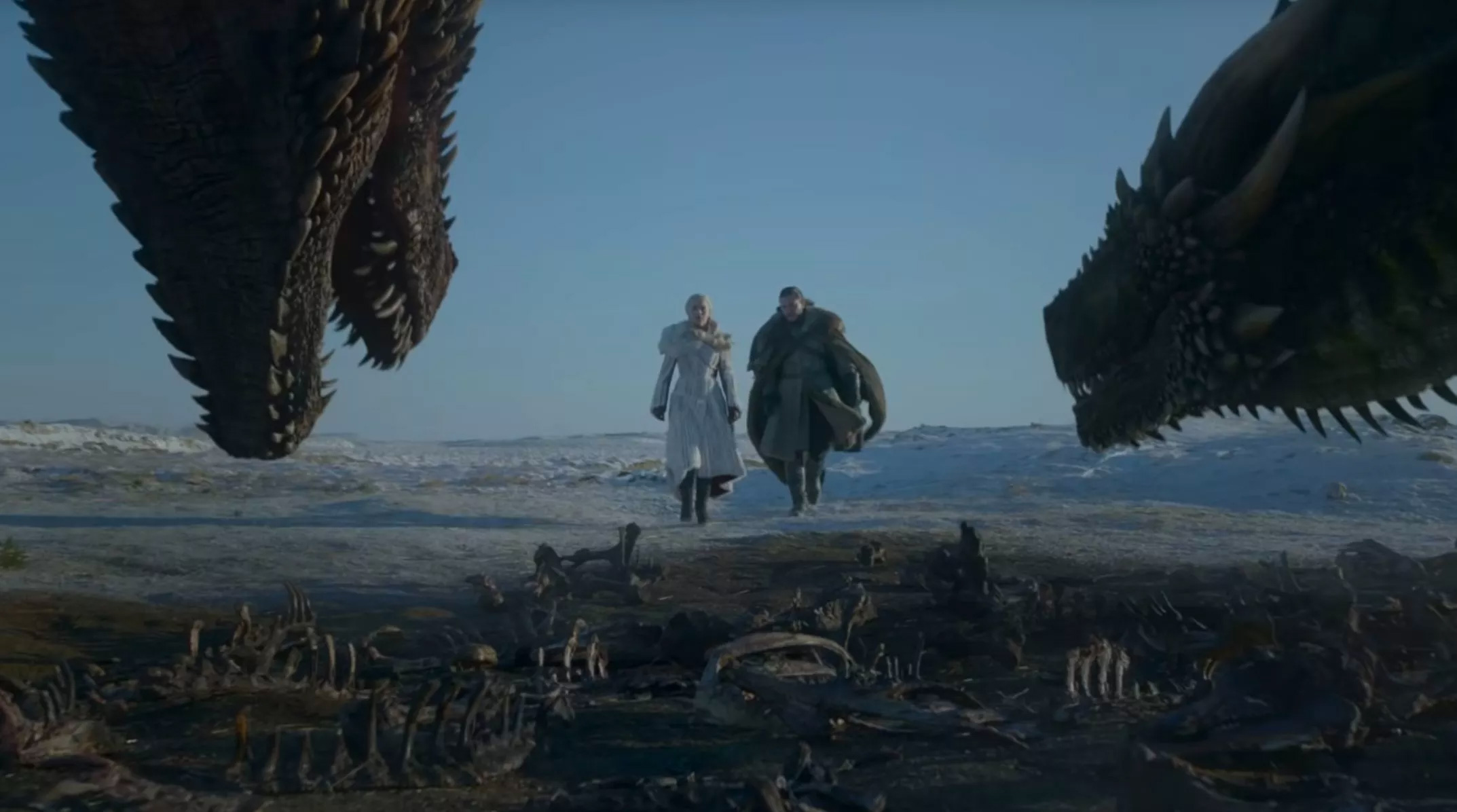 Jon Snow and Daenerys from Game of Thrones shown walking between two dragons