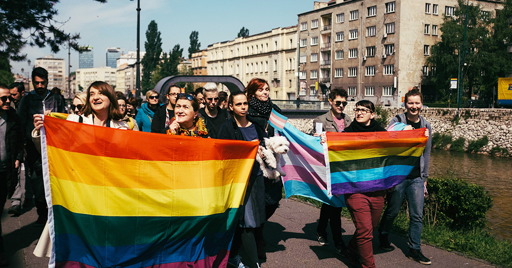 LGBT activists in Bosnia marching by the river with rainbow flags