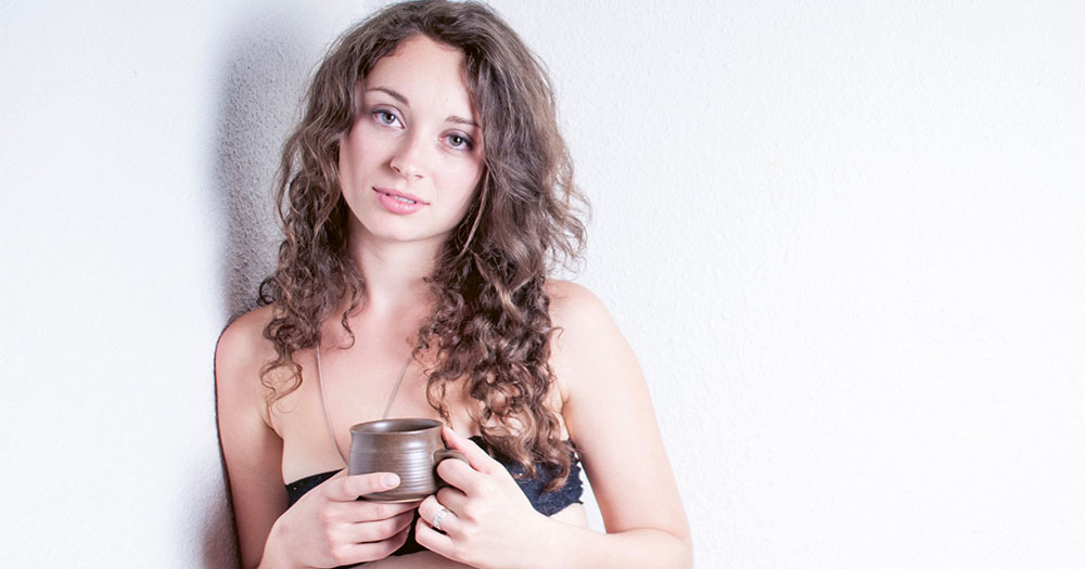 Promo for Revolting Women at the International Dublin Gay Theatre Festival featuring a young woman leaning against a wall holding a coffee cup