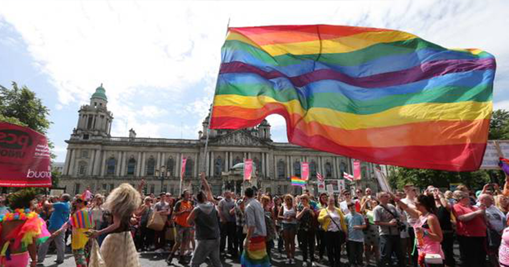 rainbow flag waves in front of city call in Pride in Belfast
