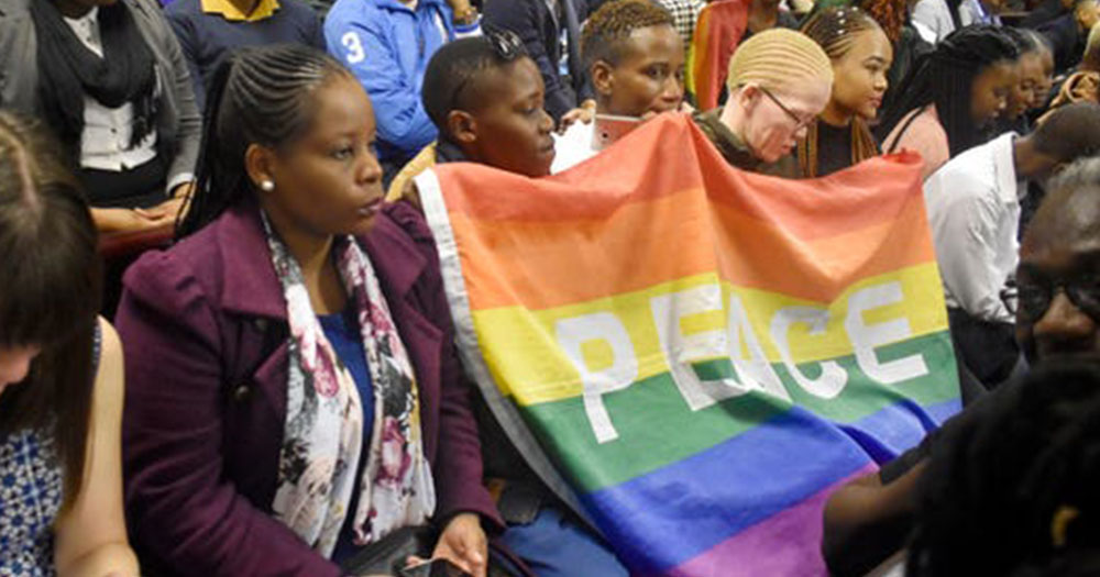 Botswana activists hold Pride flag with the word "Peace" on it