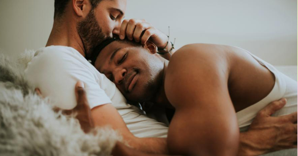 two men cuddle with intimacy