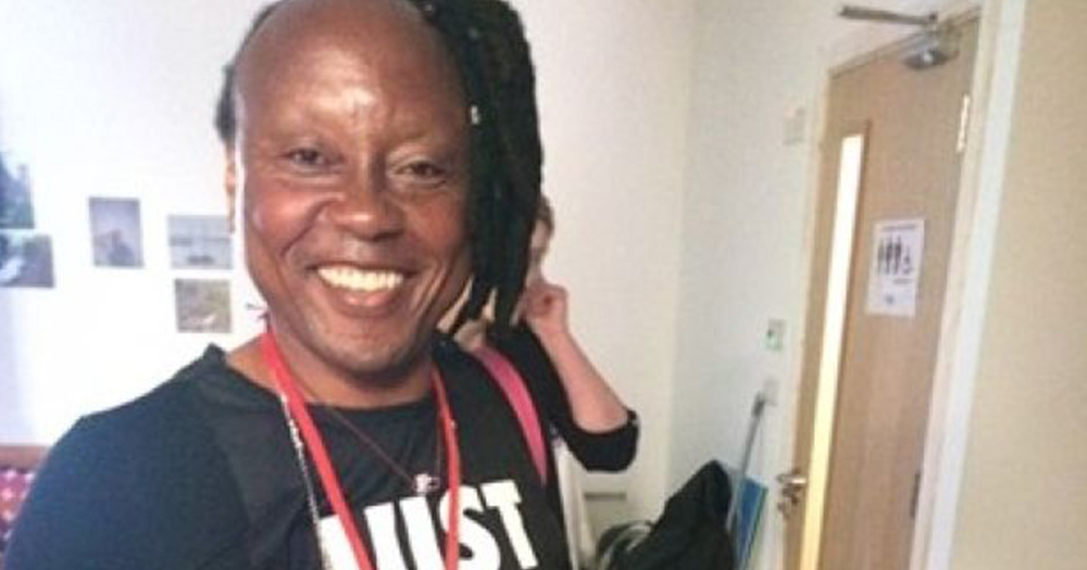 Sylva Tukula, her hair pulled to the side in dreads, smiles at the camera