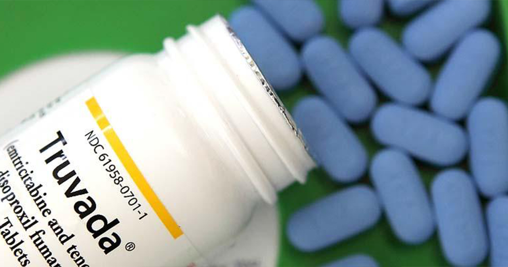blue PrEP pills and bottle that reads 'Truvada' sits on table