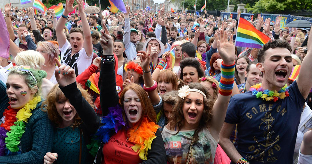 Revellers at Pride in city centre cheer while decked out in rainbow regalia