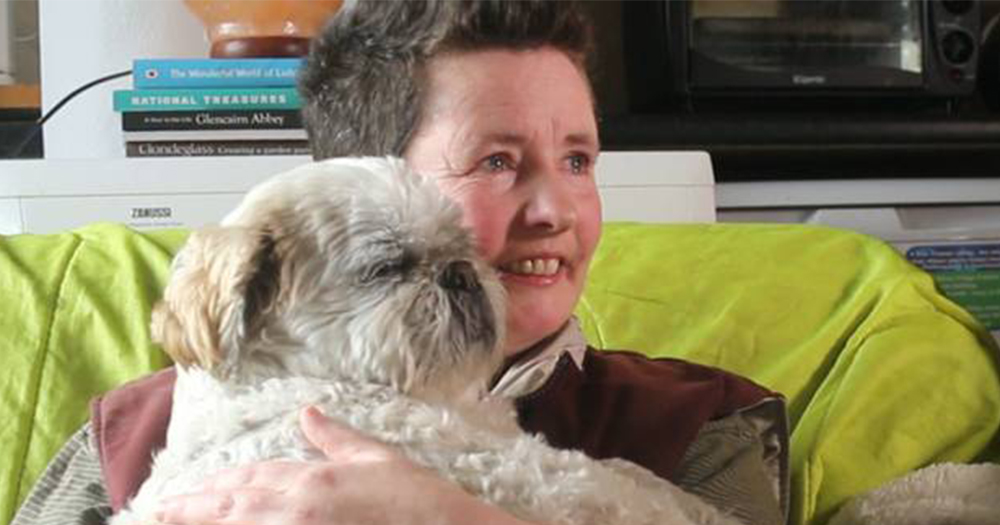 A male member of TransGreystones on a couch holding his dog